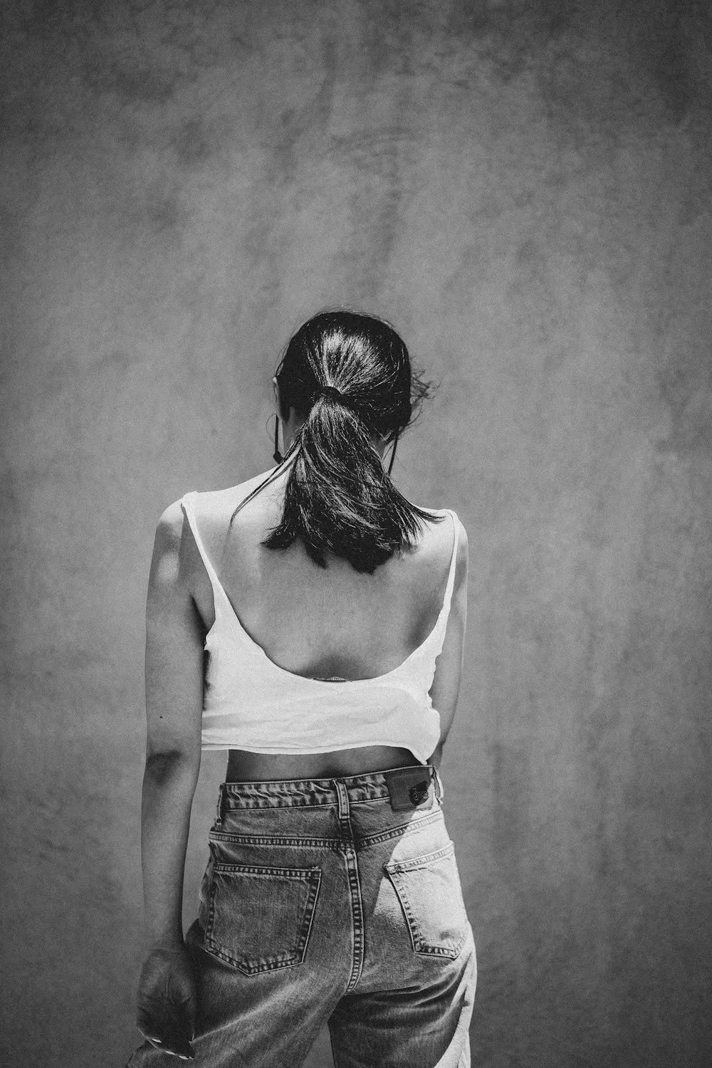 woman in white tank top and blue denim bottoms