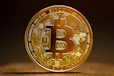 a golden bitcoin sitting on top of a table