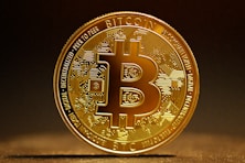 a golden bitcoin sitting on top of a table