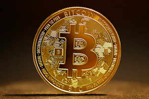 a golden bitcoin sitting on top of a table