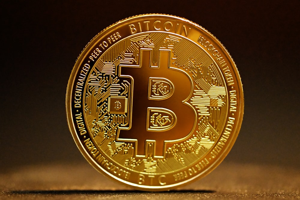 a golden bitcoin sitting on top of a table