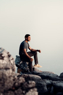 A thoughtful person sitting quietly, gazing out over a vast landscape.