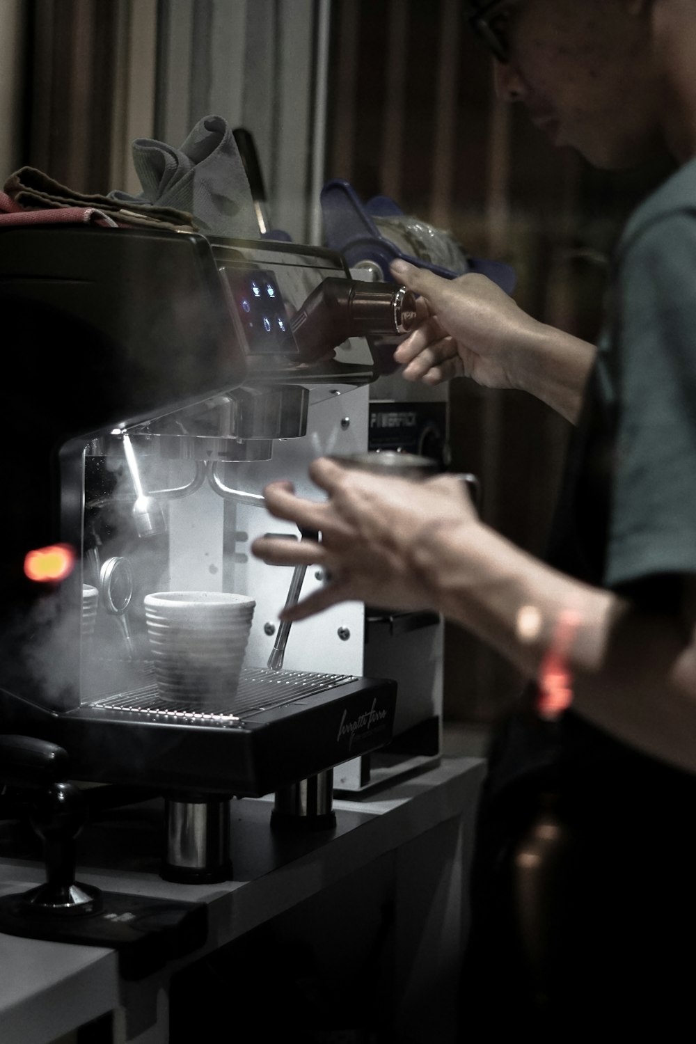 person in gray long sleeve shirt holding silver and black espresso machine