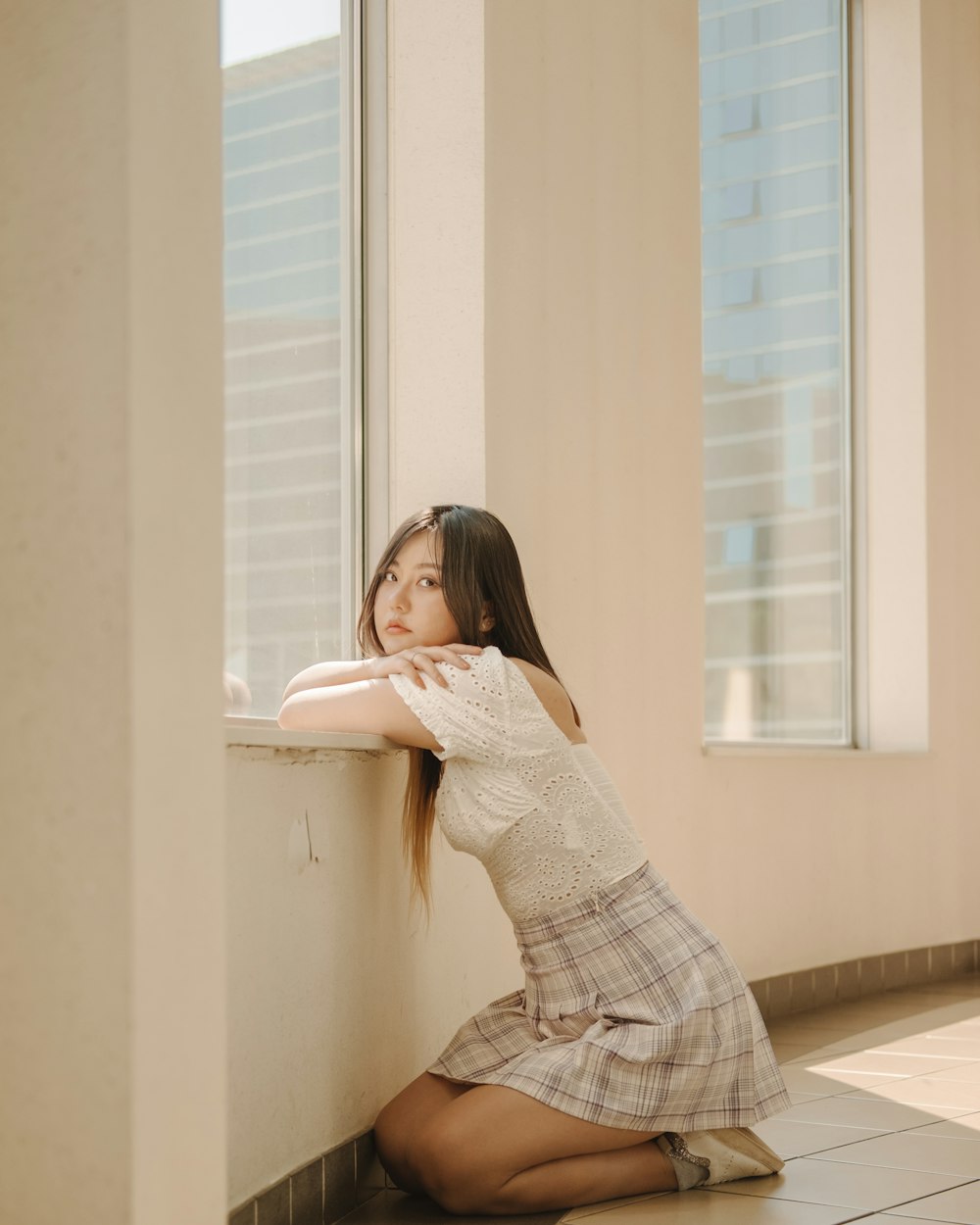 woman in white long sleeve shirt sitting on white window