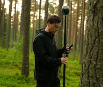 man in black jacket holding black and gray stick