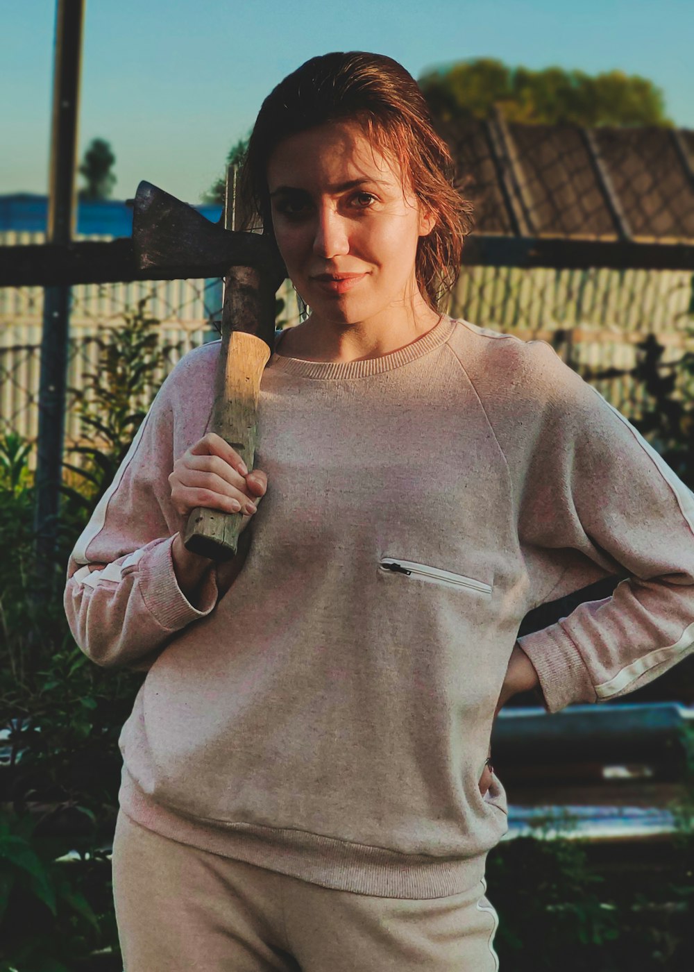 woman in gray long sleeve shirt holding brown and black axe