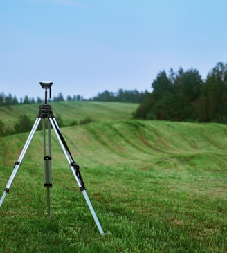 black and white tripod on green grass field during daytime