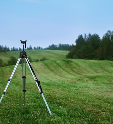 black and white tripod on green grass field during daytime