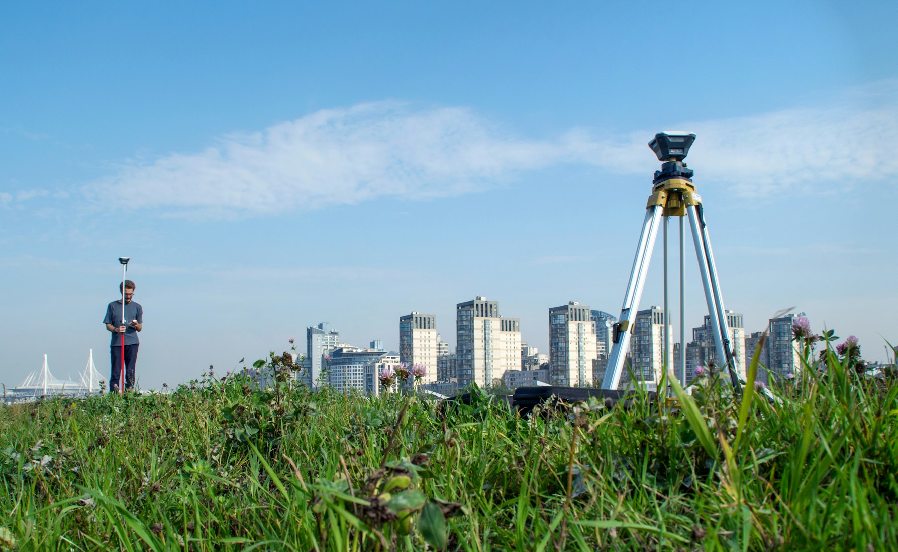 Tripé de topografia com a cidade ao fundo