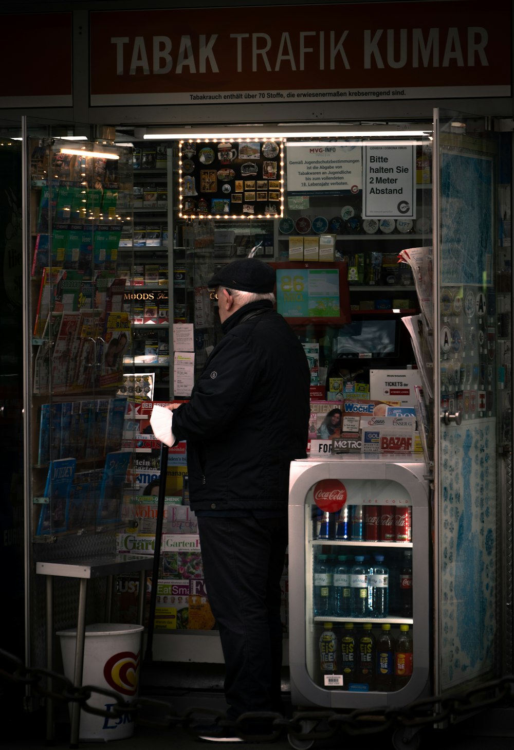 man in black jacket standing in front of store