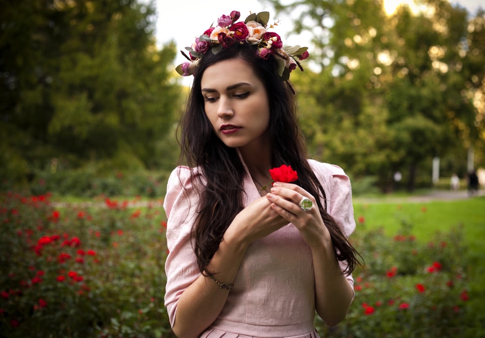 woman in pink long sleeve shirt with red and white floral headband