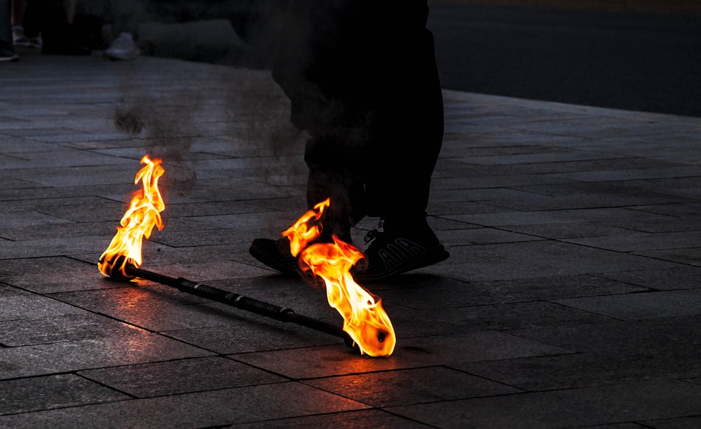man in black jacket standing near bonfire