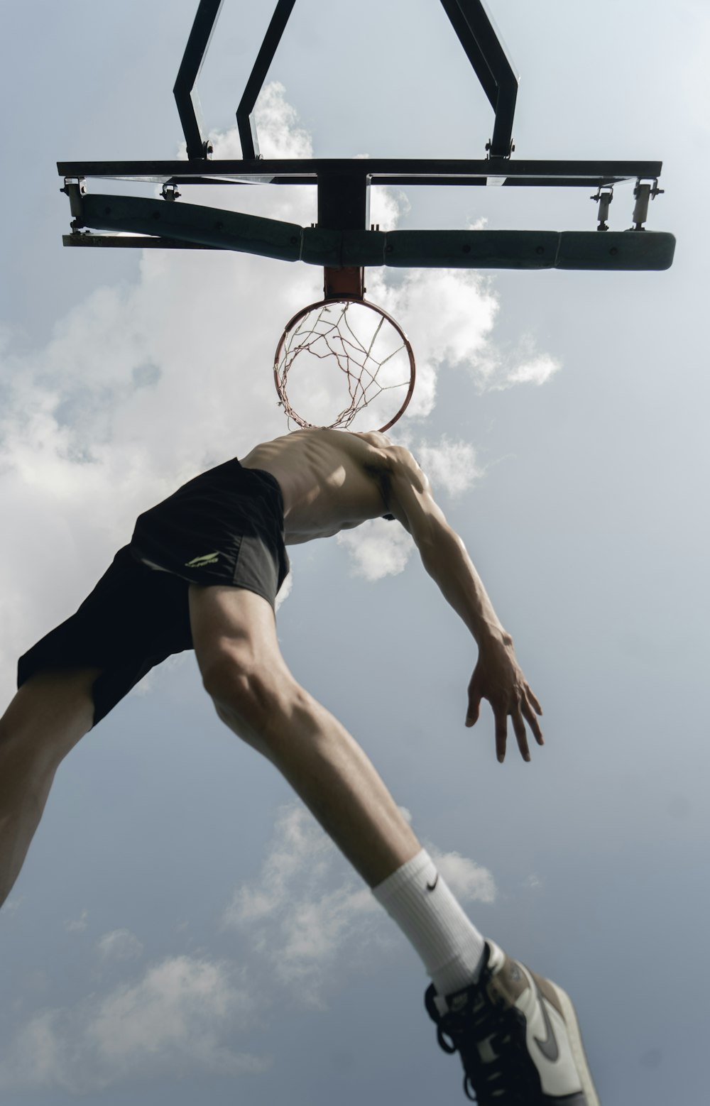 黒いタンクトップと黒いショートパンツでバスケットボールをしている女性