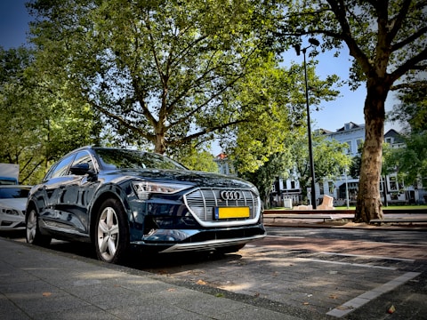 Sleek luxury car parked in front of Prague's historic cityscape at sunset.
