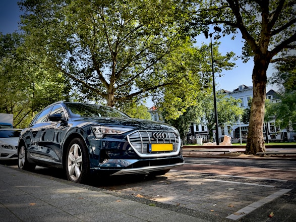 A sleek luxury car parked on a stylish street in Lausanne at dusk.