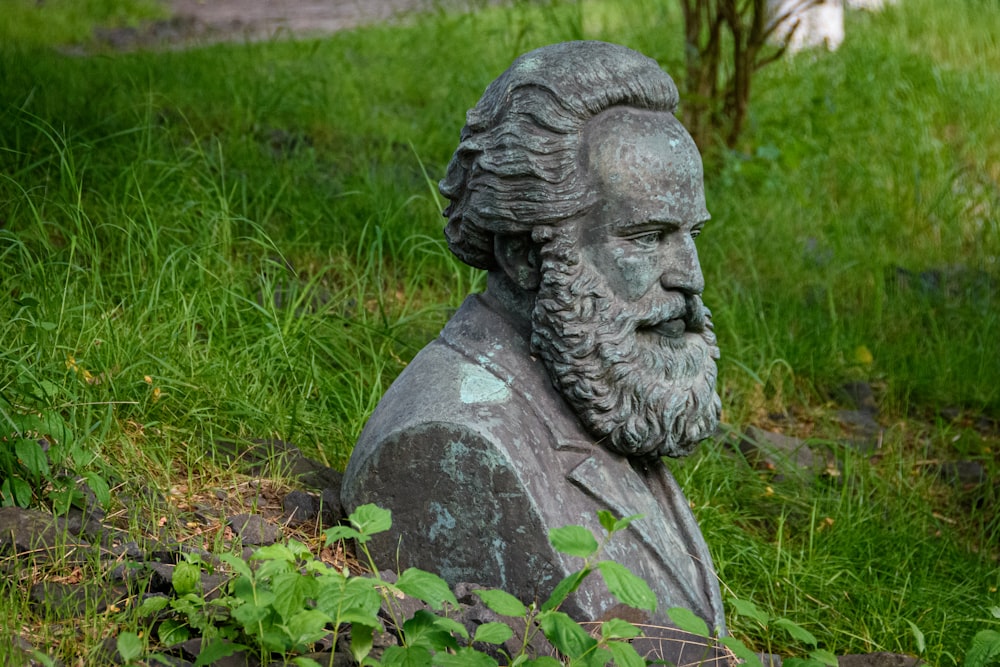 estátua cinzenta de concreto no campo verde da grama durante o dia