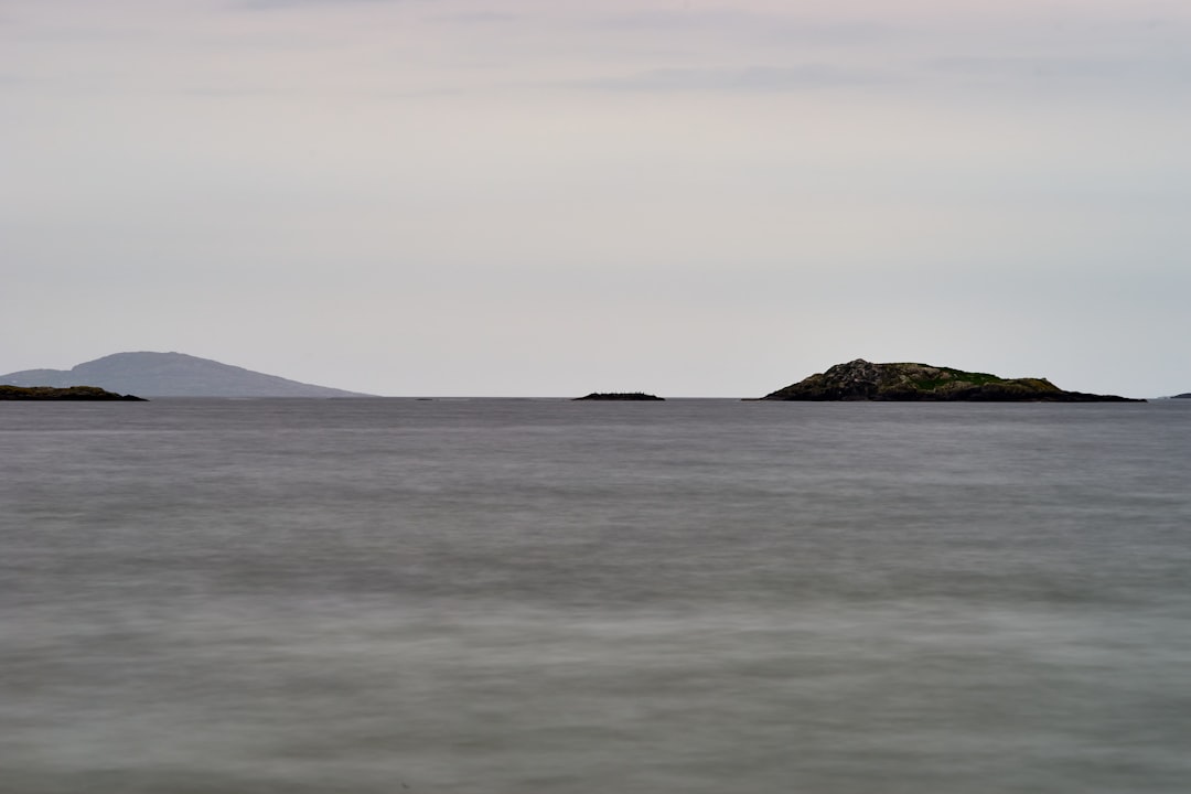 body of water near mountain during daytime