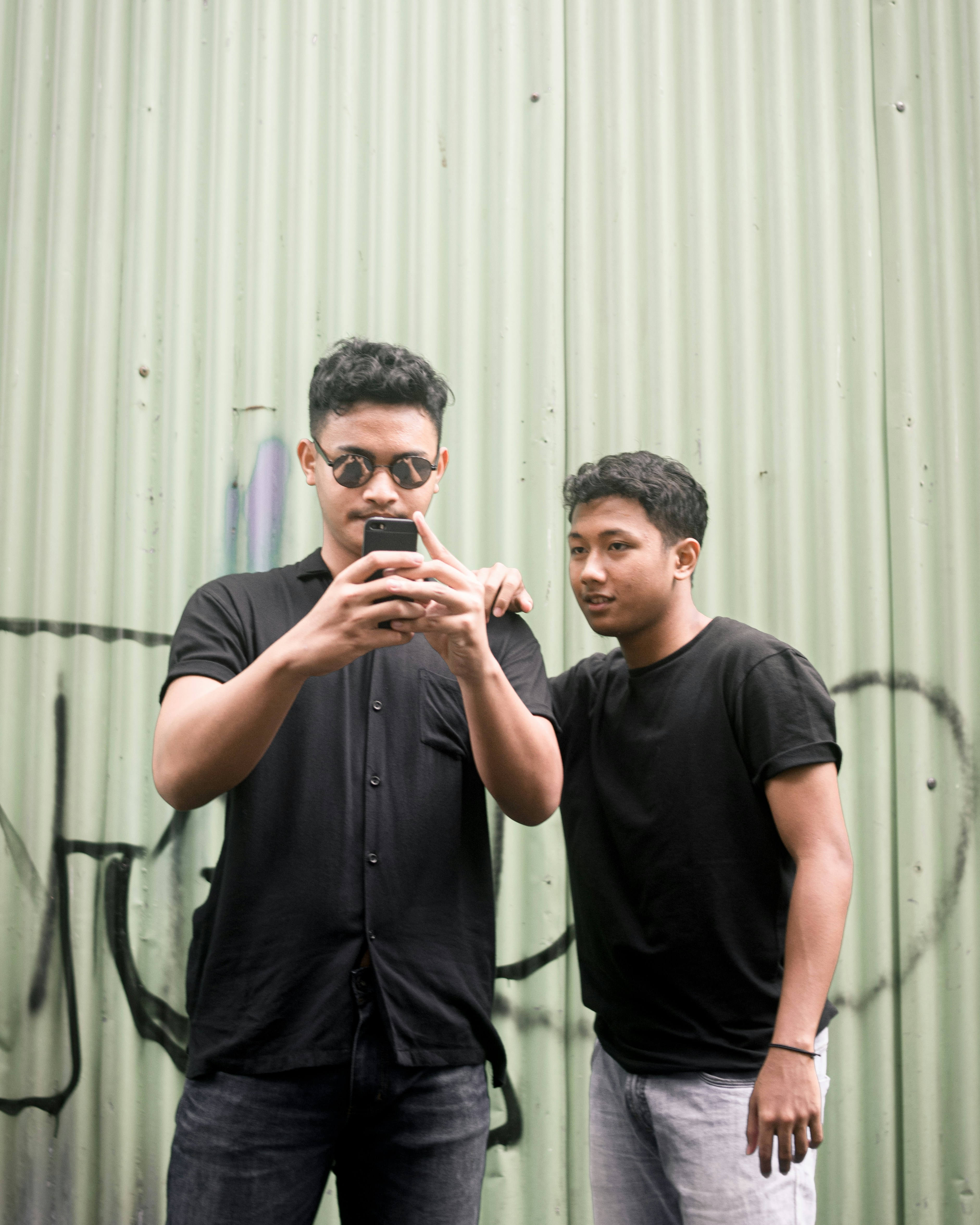 man in black crew neck t-shirt holding smartphone