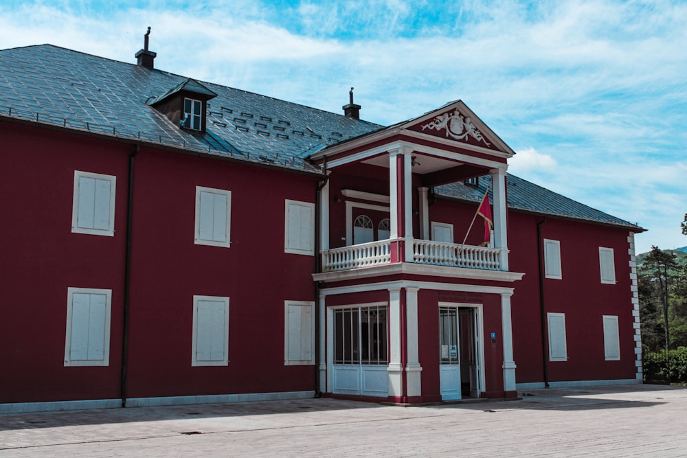 edifício de concreto vermelho e branco sob o céu azul durante o dia