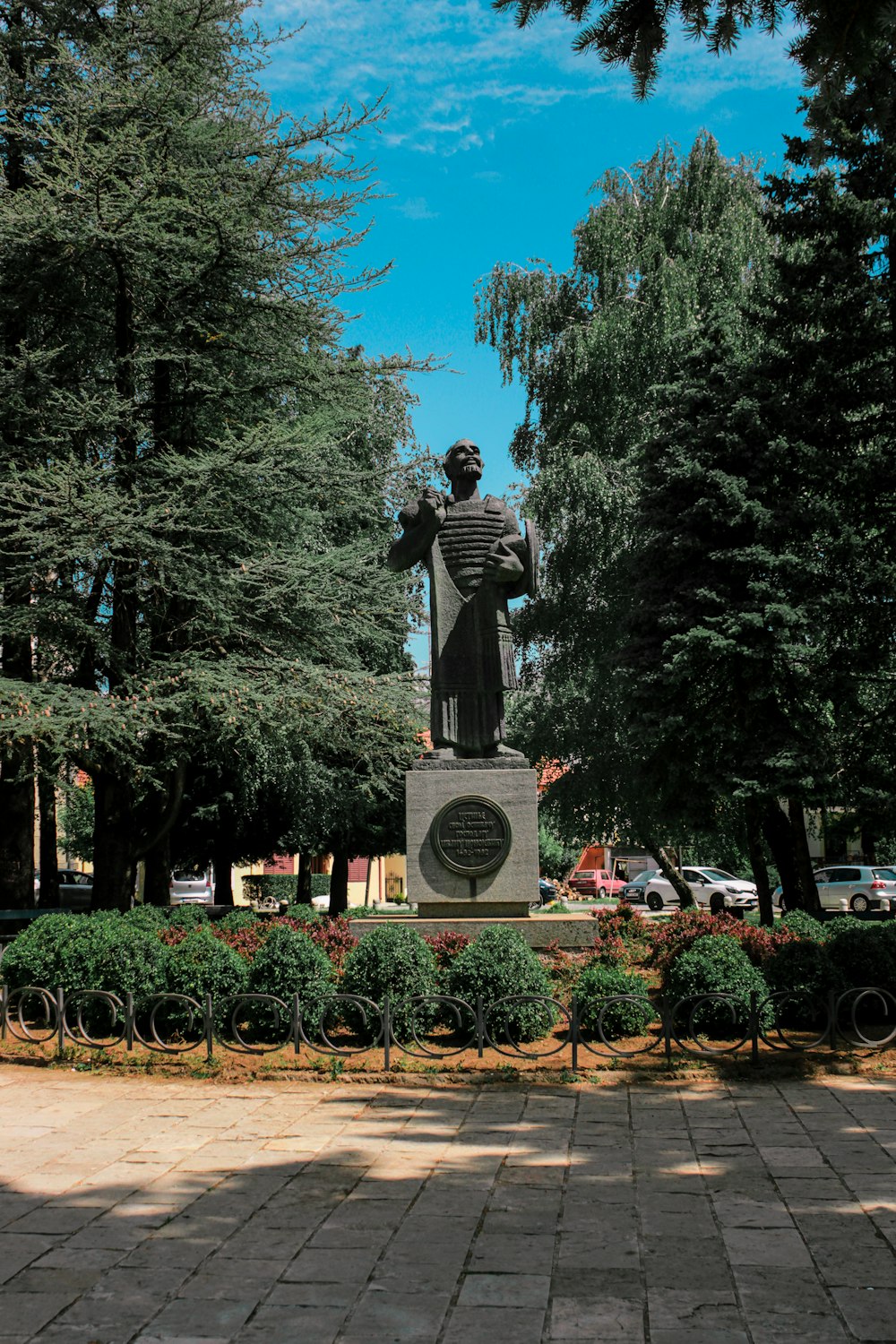 Statua grigia vicino agli alberi verdi durante il giorno