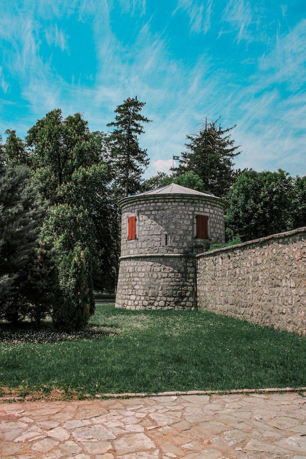 brown brick house in the middle of green trees