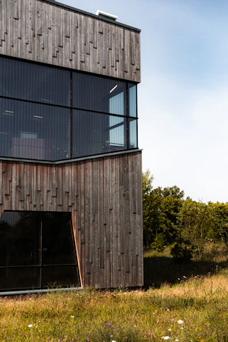 brown wooden building near green trees during daytime