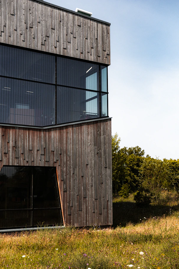 brown wooden building near green trees during daytime