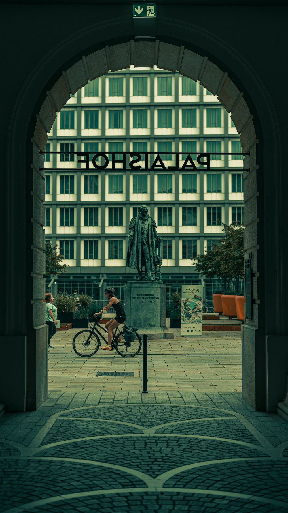 man in black jacket riding bicycle near building during daytime