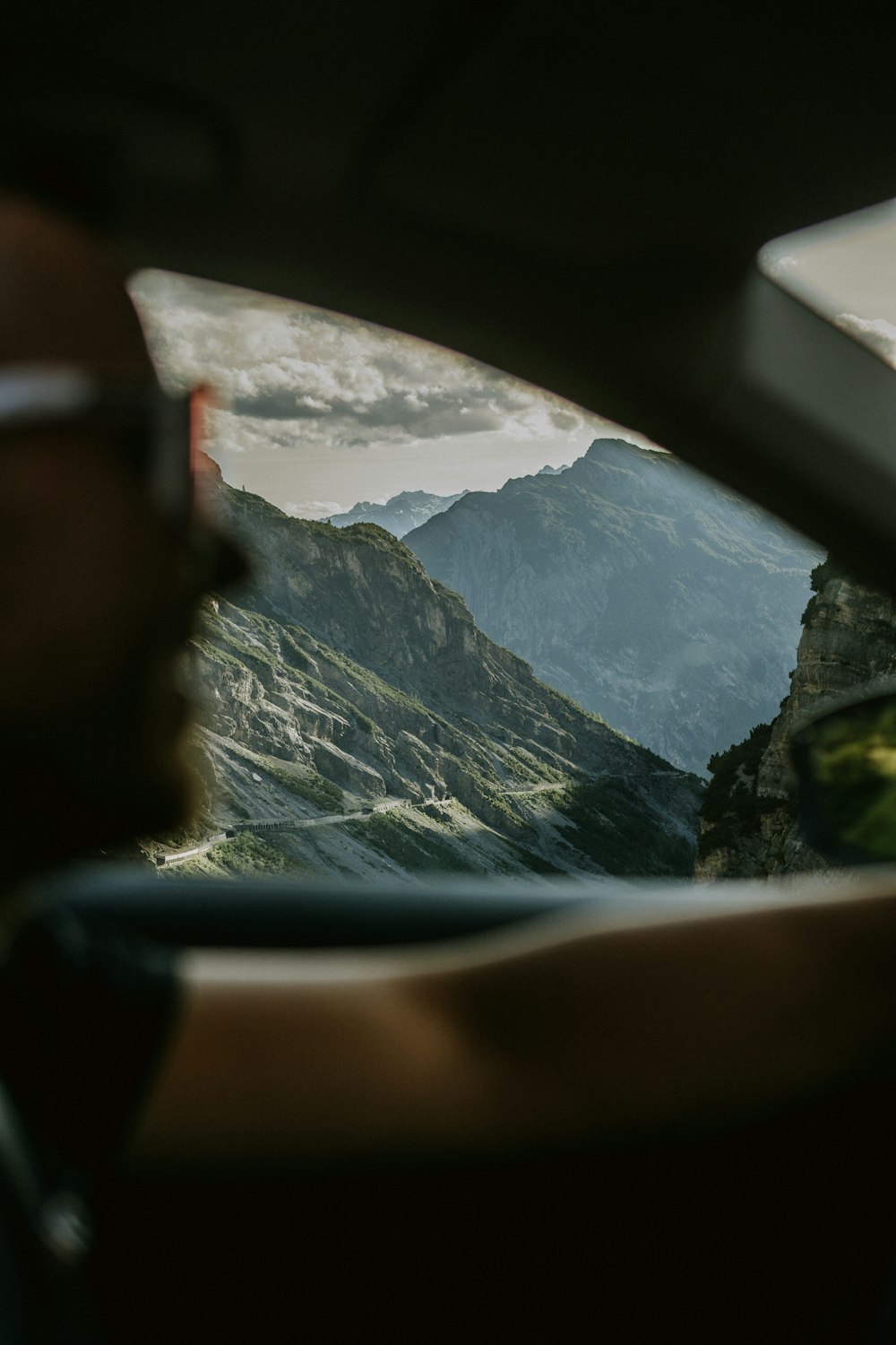 person wearing black sunglasses sitting on car