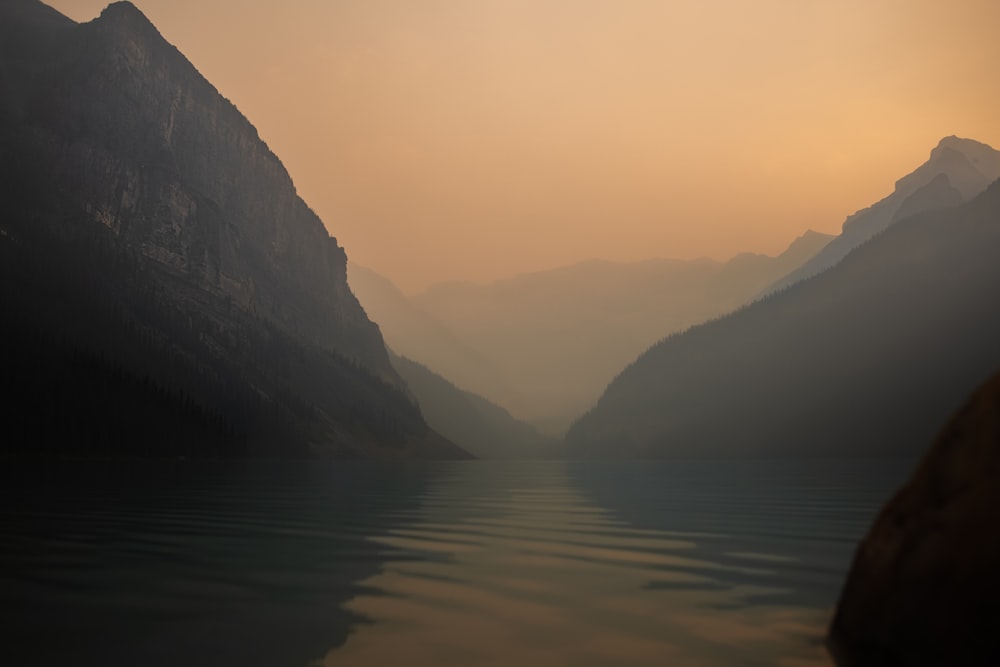 lake in the middle of mountains during daytime