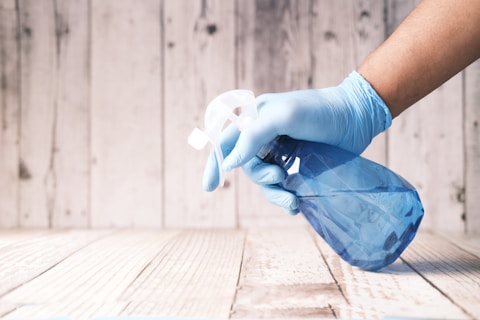 person holding blue spray bottle