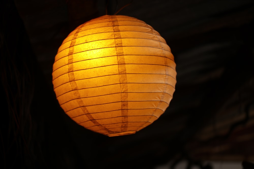 orange paper lantern turned on in dim light
