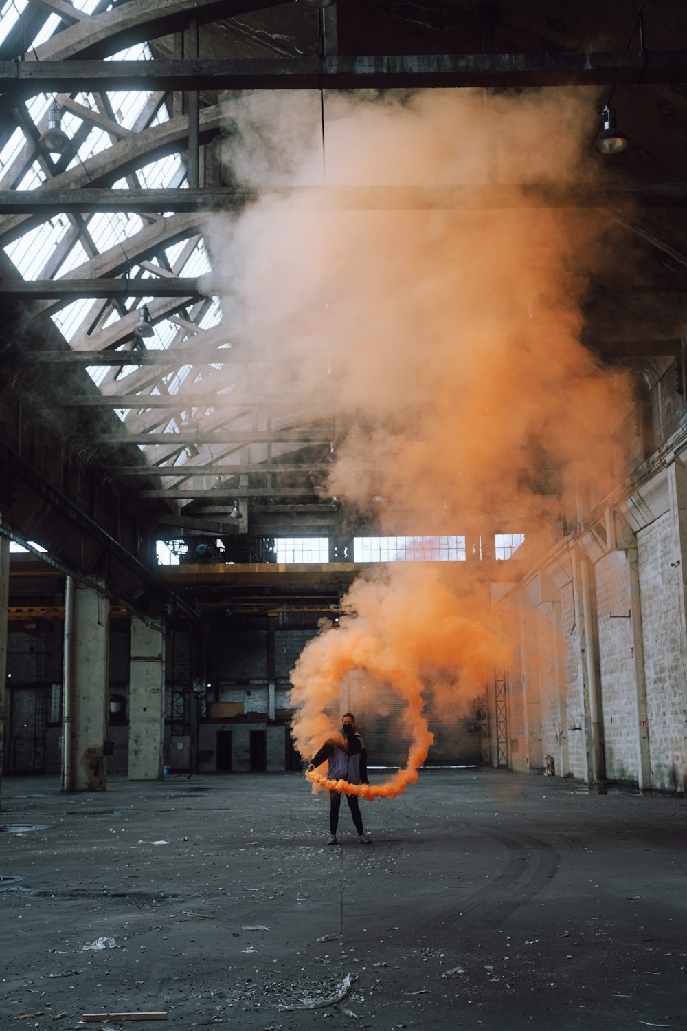 man in black jacket standing on gray concrete floor