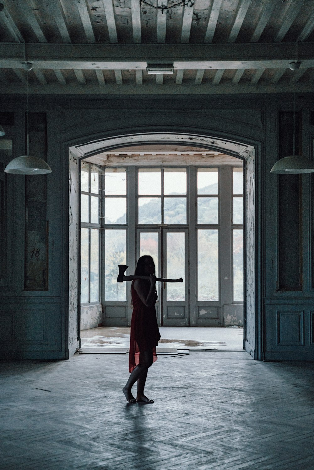 Femme en chemise noire à manches longues et jupe rouge debout devant une porte en bois marron