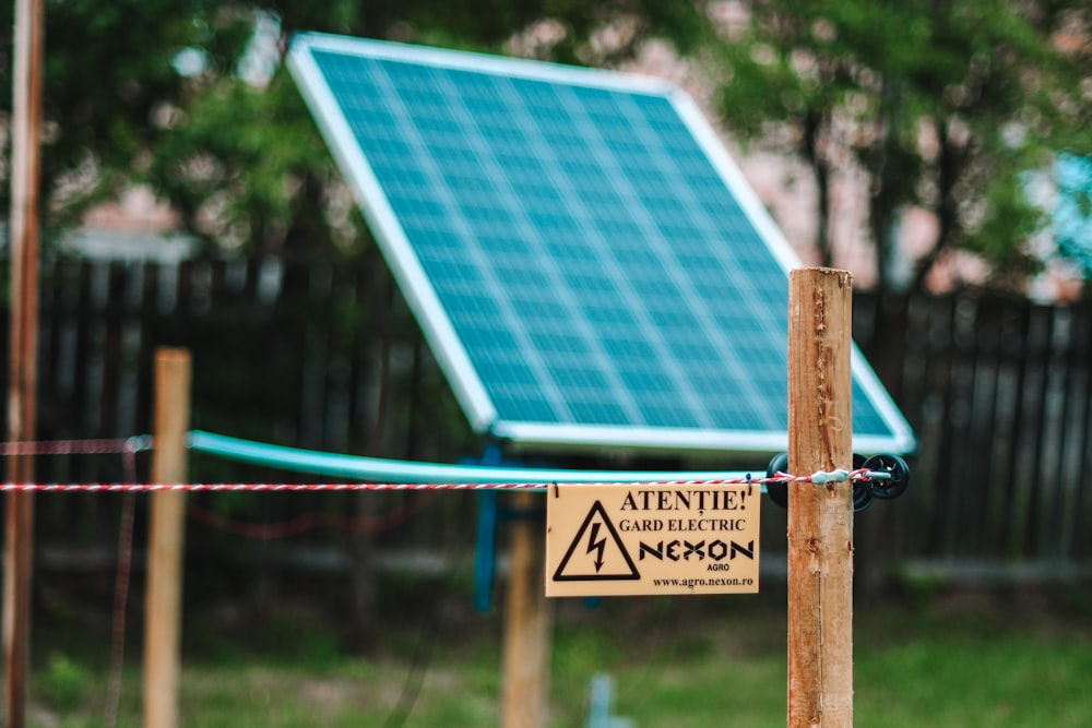 blue and white solar panel on brown wooden post