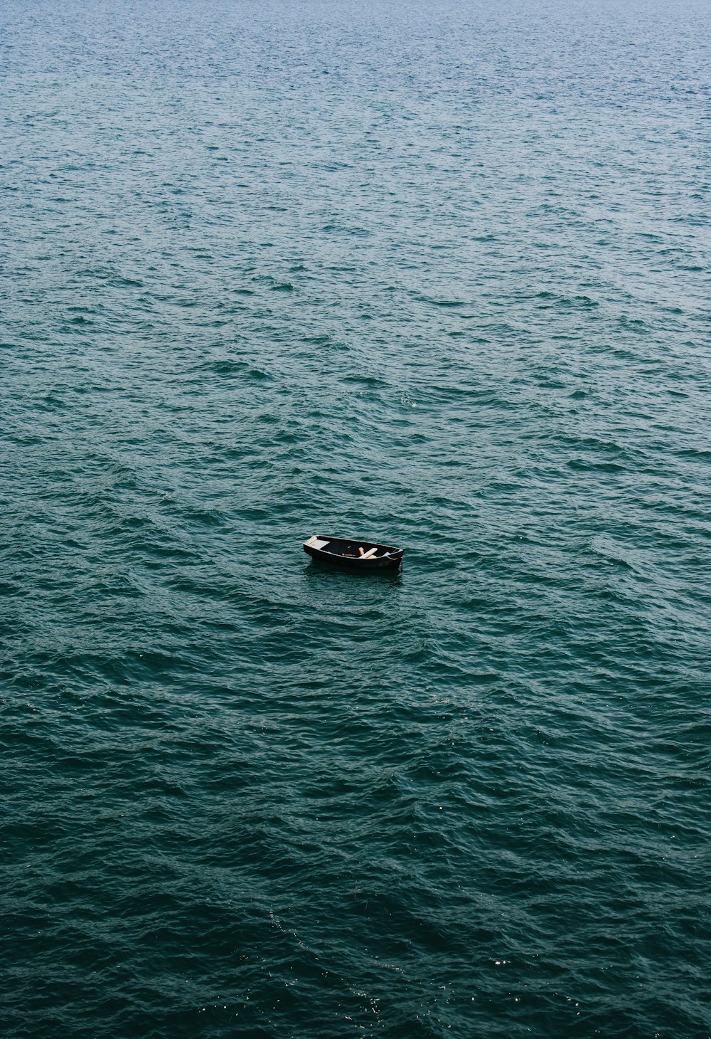 black boat on body of water during daytime