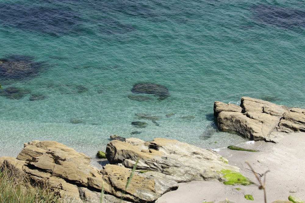 brown rock formation beside body of water during daytime