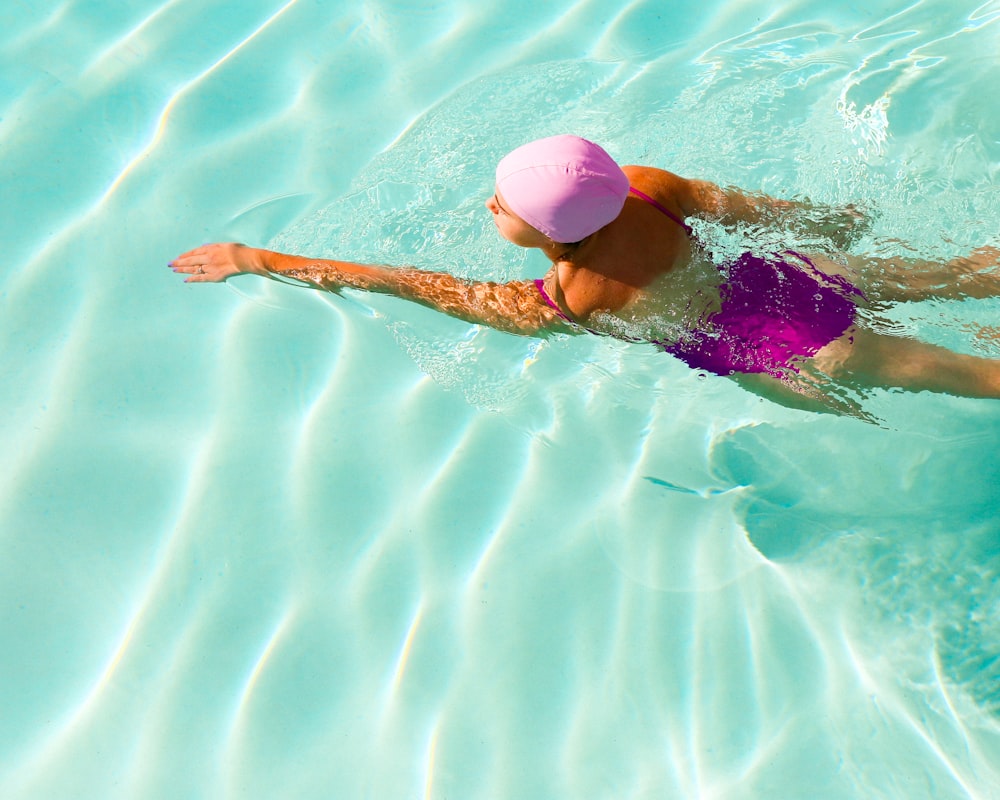 woman in pink bikini swimming on water