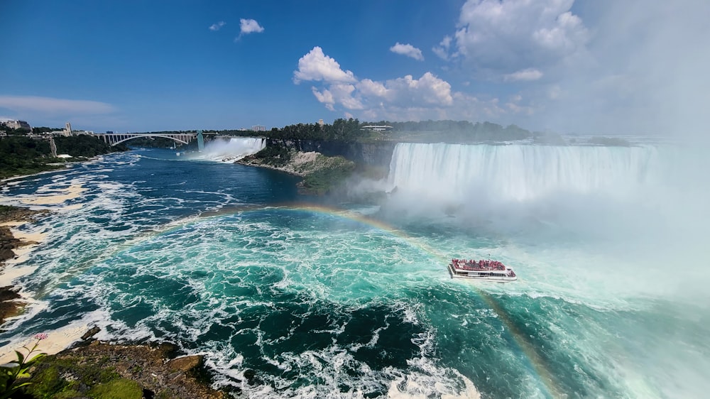 white and red boat on water falls during daytime