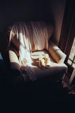Elegant espresso brown silk pajamas draped over a plush ivory armchair in a softly lit room