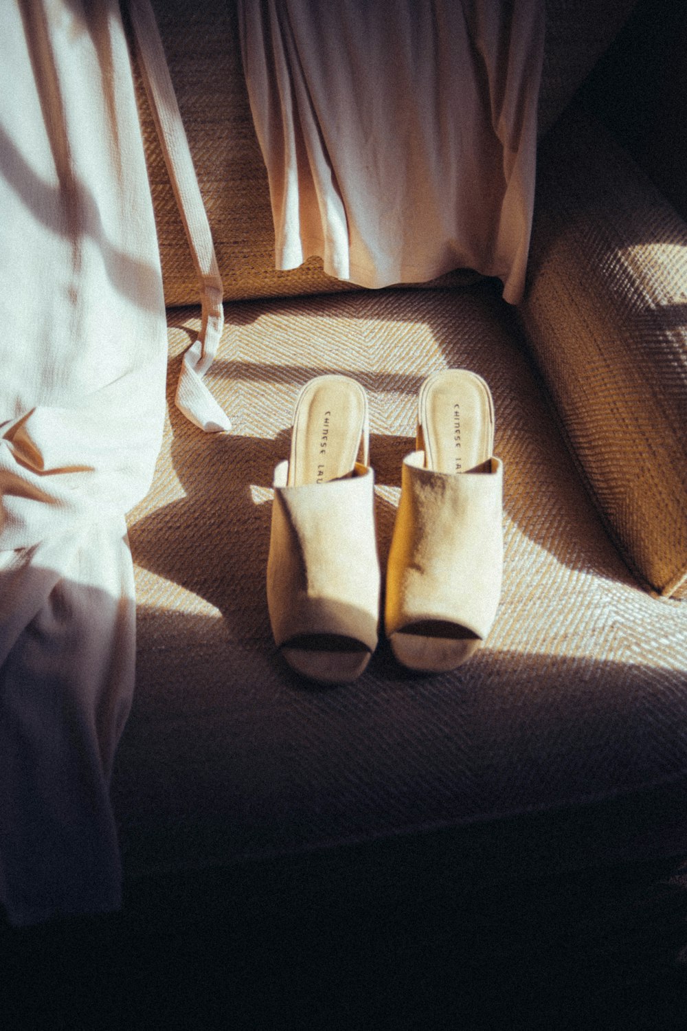 white leather sandals on brown textile