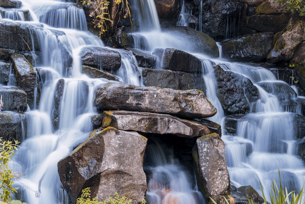 brown and gray rock formation with water falls