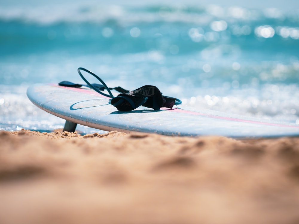 black and white surfboard on beach shore during daytime