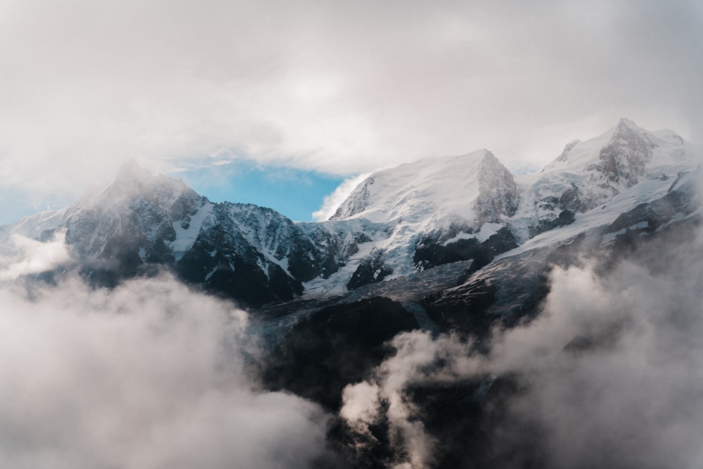 snow covered mountains under cloudy sky during daytime