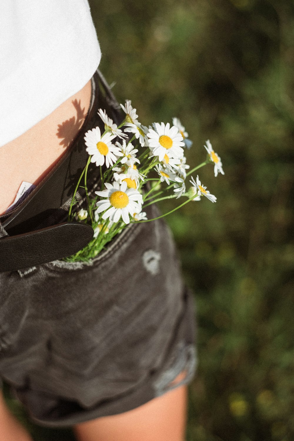 person in gray shirt with white daisy flowers on her lap