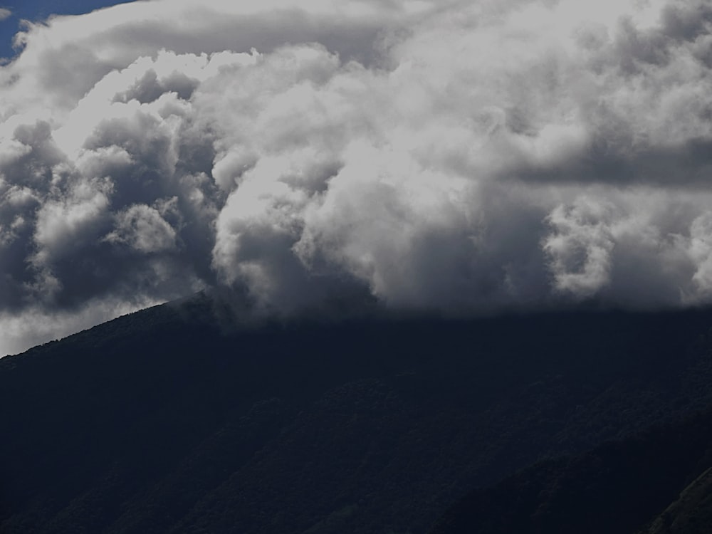 white clouds over black mountain