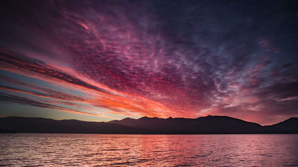 body of water under cloudy sky during sunset