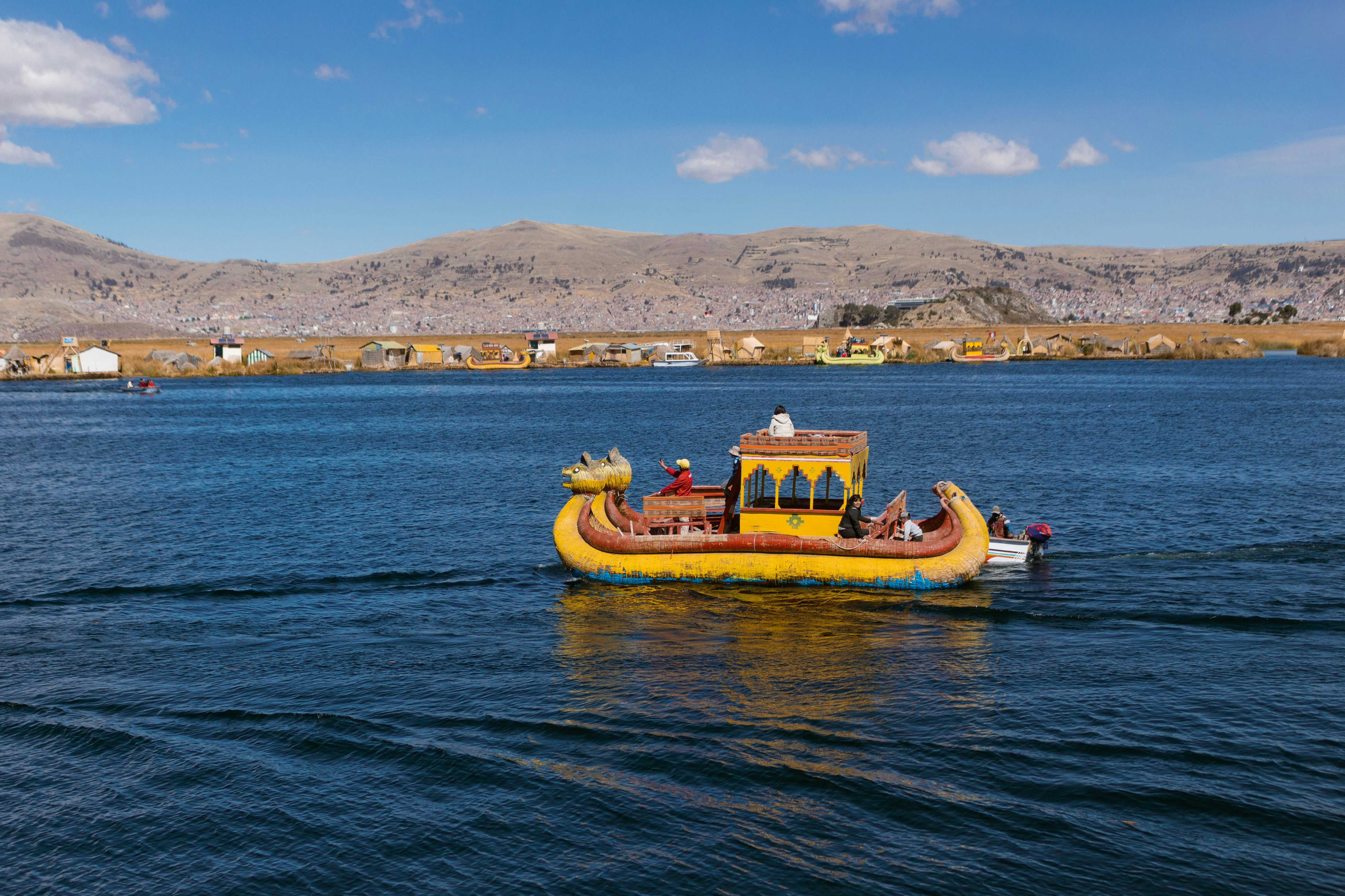 bateau traditionnel sur le lac Titicaca avec îles en arrière plan.