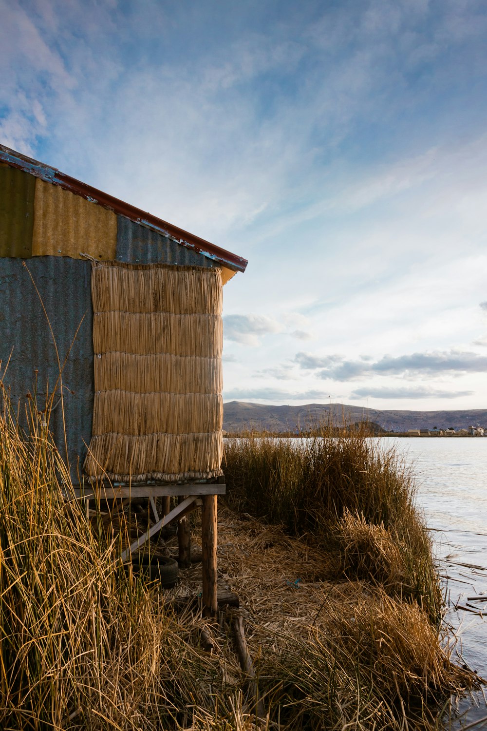 brown wooden house near body of water during daytime