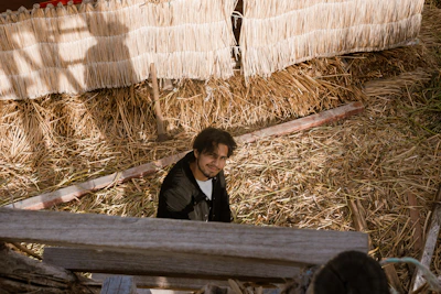 A smiling face with dirt-smudged hands, proud after building a survival shelter.